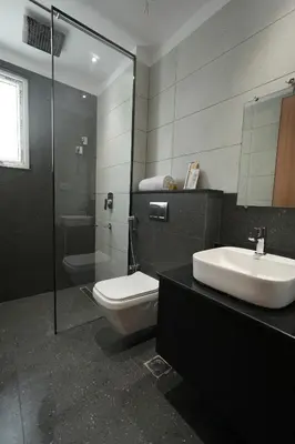 a bathroom with a toilet and a sink and a shower at Hotel Cachet in Coimbatore