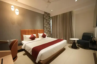 a hotel room with a bed and a chair at Hotel Cachet in Coimbatore