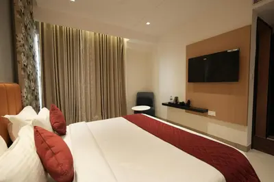 a hotel room with a bed and a flat screen tv at Hotel Cachet in Coimbatore