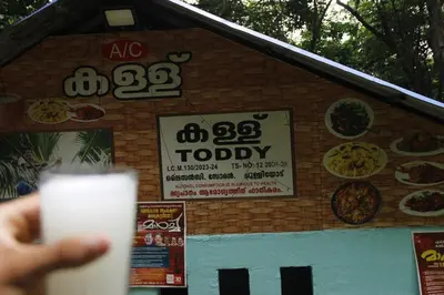 a person holding a drink in front of a pizza shop at Nilambu Homestay in Nilambūr