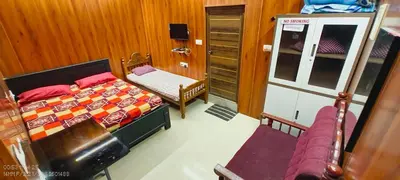 a small bedroom with a bed and a chair at Sree guruvayoorappan inn in Guruvāyūr