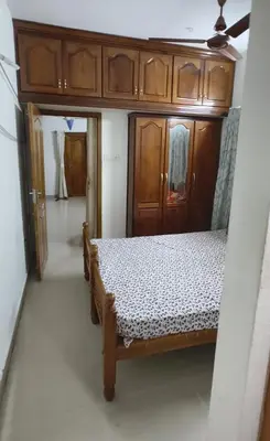 a bedroom with a bed and wooden cabinets at Sree guruvayoorappan inn in Guruvāyūr