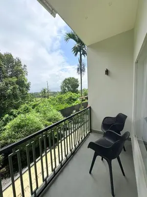 a balcony with two chairs and a view at Cozycaza resort in Padinjarathara