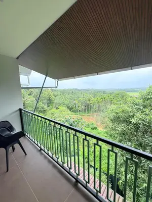 a balcony with a view of the forest at Cozycaza resort in Padinjarathara