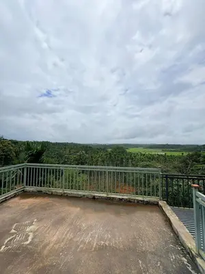 a balcony with a view of the countryside at Cozycaza resort in Padinjarathara