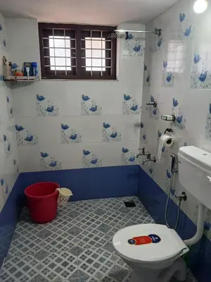 a blue and white bathroom with a toilet and a sink at Staycation Homestay in Ernakulam