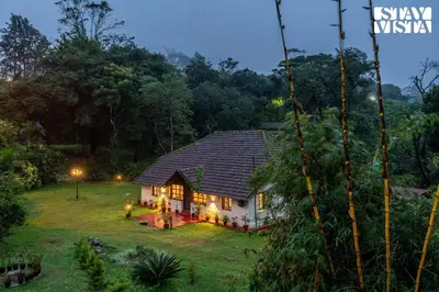a house in the middle of a yard at night at The Fig Tree Villa by VEO - Part of StayVista in Madikeri
