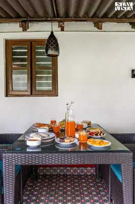 a table with plates of food on it at The Fig Tree Villa by VEO - Part of StayVista in Madikeri