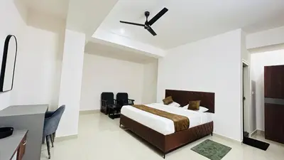 a bedroom with a bed and a ceiling fan at Queens Suite Rooms in Channapatna