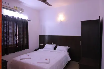 a bedroom with two beds with white sheets at PVR International in Coimbatore