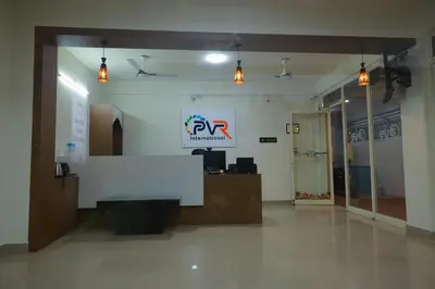 an office with a reception desk and a sign on the wall at PVR International in Coimbatore