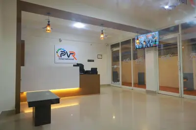 a large room with a podium and a sign on the wall at PVR International in Coimbatore