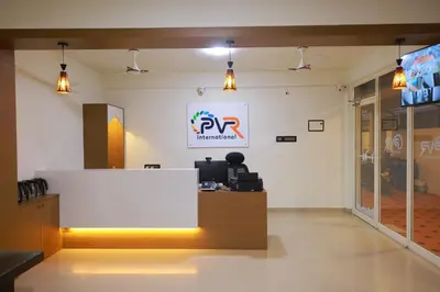 an office with a reception desk and a sign on the wall at PVR International in Coimbatore