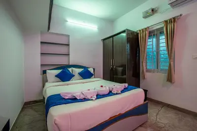 two beds in a room with pink and blue at Sree Bharat Apartment in Coimbatore