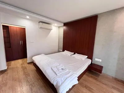 a bedroom with a large bed with white sheets at FARIS ROOMs in Malappuram