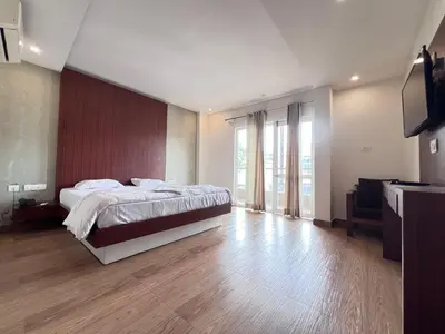 a large bedroom with a bed and a television at FARIS ROOMs in Malappuram