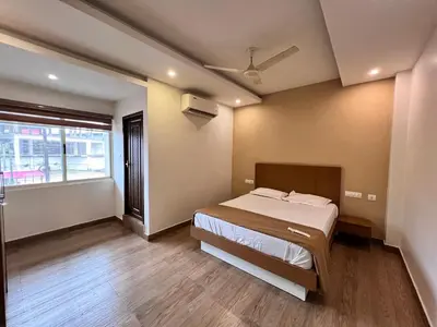 a bedroom with a bed and a large window at FARIS ROOMs in Malappuram