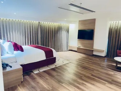 a bedroom with a bed and a television in a room at Oshin Calicut in Kozhikode