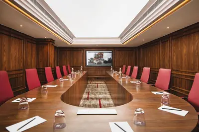 a large conference room with a long table and red chairs at Oshin Calicut in Kozhikode