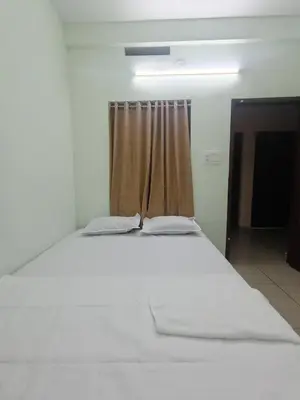 a white bed in a room with a window at bohom STAYORA in Nedumbassery