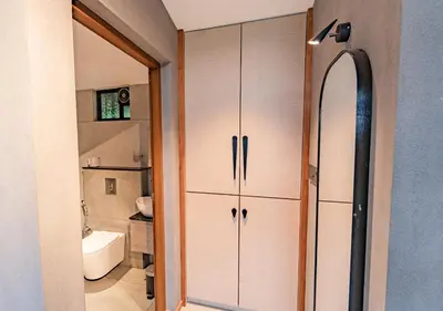 a bathroom with white cabinets and a sink and a toilet at Alaya Boutique Villa with Dam View by VOYE HOMES in Vythiri