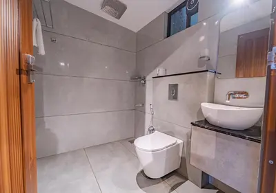 a bathroom with a toilet and a sink at Alaya Boutique Villa with Dam View by VOYE HOMES in Vythiri