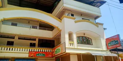 a white building with a balcony on a street at Mahe Residency in Mahe