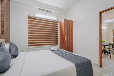 a bedroom with a large white bed and a window at D Nest Inn in Trichūr