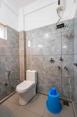 a bathroom with a toilet and a shower at D Nest Inn in Trichūr