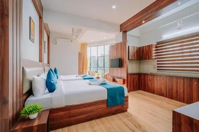 a bedroom with a large bed with blue pillows at D Nest Inn in Trichūr