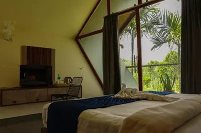 a bedroom with a bed and a large window at Hayashi Resort in Meppādi