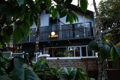 a black and white building with a balcony at Hayashi Resort in Meppādi