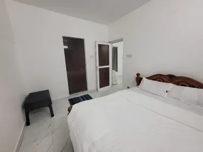 a white bedroom with a large bed and a window at Zirku Garden Kodaikanal in Kodaikānāl