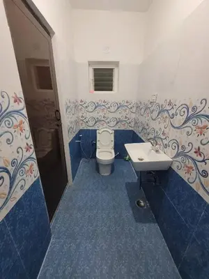 a blue and white bathroom with a toilet and a sink at Zirku Garden Kodaikanal in Kodaikānāl