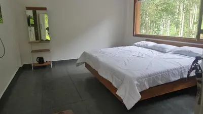 a bedroom with a large bed with a window at Hamai Grand Home Stay Rooms Wayanad in Ambalavayal