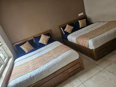 two beds sitting next to each other in a room at Hamai Grand Home Stay Rooms Wayanad in Ambalavayal