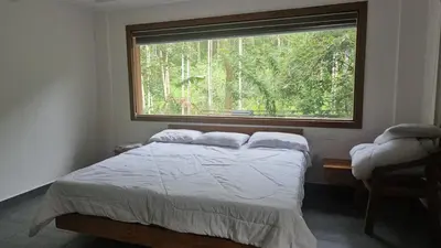 a bedroom with a bed and a large window at Hamai Grand Home Stay Rooms Wayanad in Ambalavayal