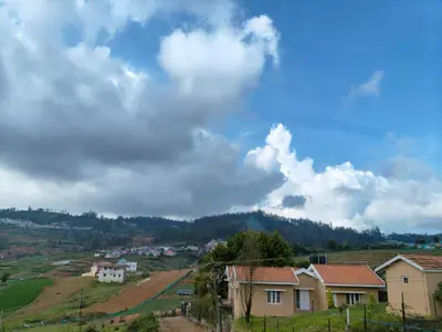 a view of a village with houses and a mountain at Westhill Daffodils Inn - II Ooty in Ooty