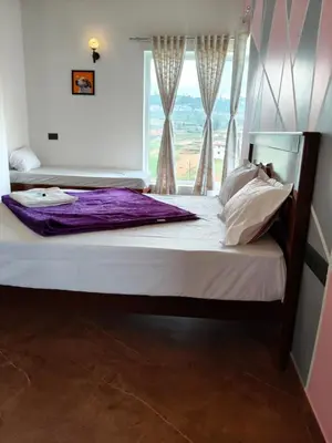 a bed in a room with a window at Westhill Daffodils Inn - II Ooty in Ooty