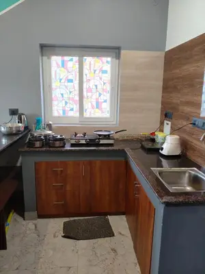 a kitchen with a counter and a sink and a window at Westhill Daffodils Inn - II Ooty in Ooty