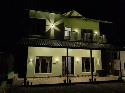 a building with a balcony on top of it at night at Westhill Daffodils Inn - II Ooty in Ooty