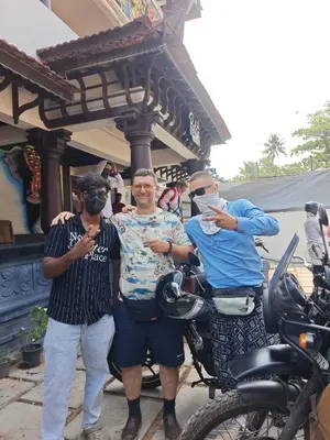 a group of three men standing next to a motorcycle at Relax inn cherai beach in Cochin