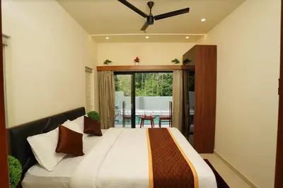 a bedroom with a bed with a ceiling fan at LA VILLA VYTHIRI Resort in Vythiri