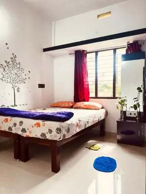 a bedroom with a bed and a window at Kannada Maathe Home Stay- Golden Temple-Tibet camp 2 km far in Kushālnagar