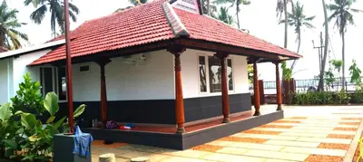 a small house with a red roof at Dhruv Heritage Lake Resort Cherai in Cochin