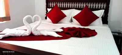 two white swansuitsrendered to be towels on a bed at Dhruv Heritage Lake Resort Cherai in Cochin