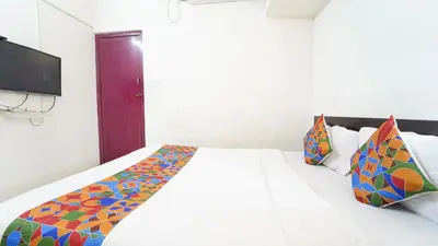 a bedroom with a white bed with colorful pillows at Honey Residency Codissia stay in Coimbatore