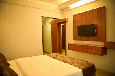 a hotel room with a bed and a flat screen tv at Hotel Manal Suites in Green Island
