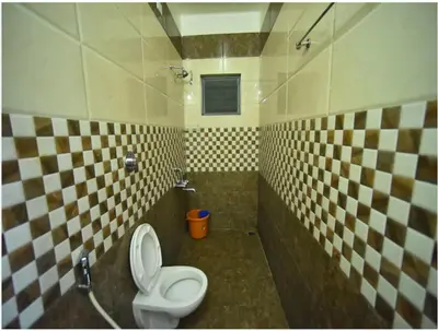 a bathroom with a toilet and a sink at PRM Aruna Lodge in Erode