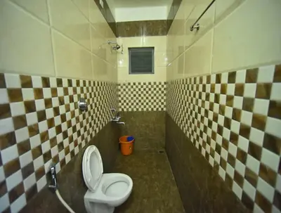 a bathroom with a toilet and a sink at PRM Aruna Lodge in Erode